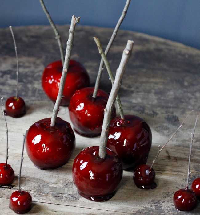 To make tiny candy apples, use a melon baller to cut small rounds from apples, using toothpicks or small branches to stick firmly into the apple, and repeat coating process, as above.